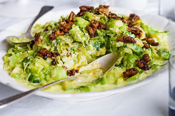 Creamed sprouts with brown buttered walnuts on a white serving platter