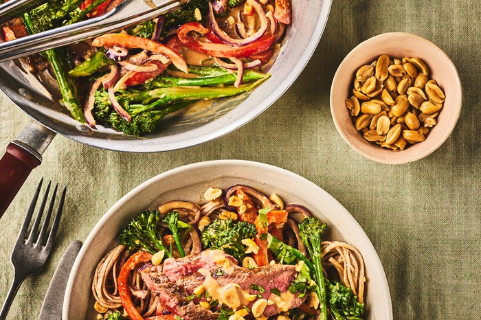 Two bowls of pepper stir-fry with nuts on the side