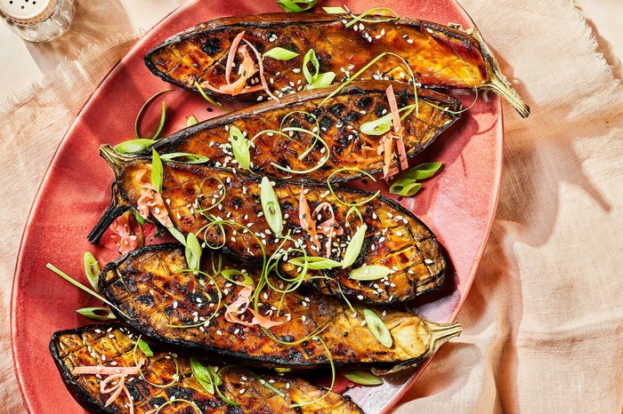 A platter of sticky aubergine on a pink plate