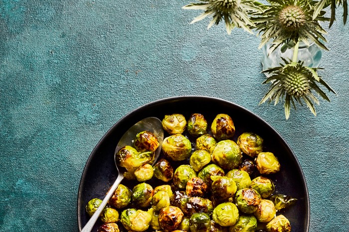 A pan of brussels sprouts with decorative foliage on the side