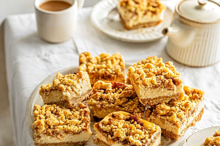 A plate of apple cheesecake bars with tea in the background