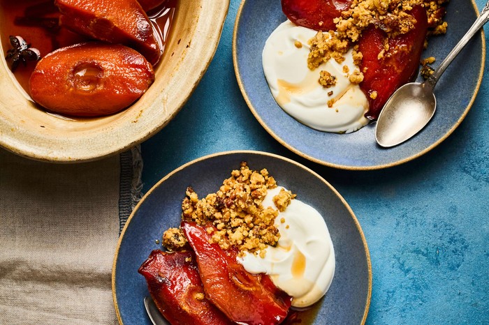 A sharing bowl of baked quince with two full plates next to it