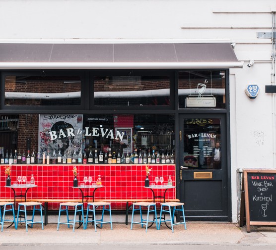 The front of Bar Levan in Peckham, with seats outside a red tiled wall