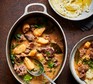 An oval casserole dish filled with a slow cooked beef and parsnip stew with a side of mashed potato