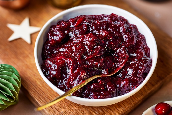 A shallow bowl fille with cranberry and port sauce with a spoon