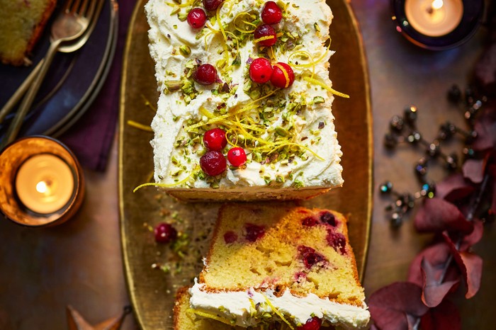 An iced loaf cake with one slice taken out of it