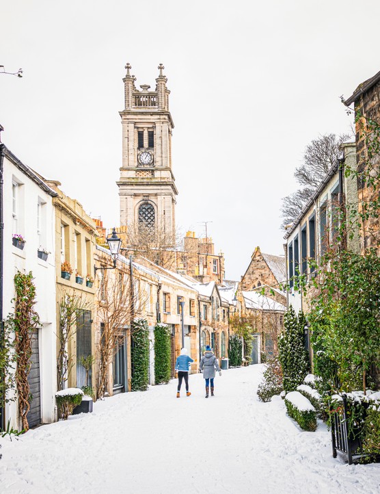 A view along a curving traditional mews street in Edinburgh's Stockbridge following heavy snow.