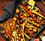 A tray of Gochujang-roasted root veg with a black kitchen cloth