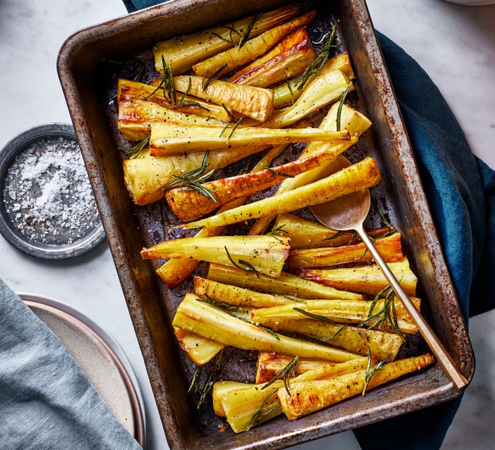 Honey-roasted parsnips with rosemary on a baking tray