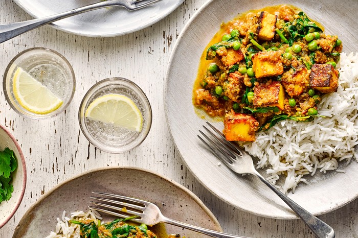 two plates of paneer curry with rice