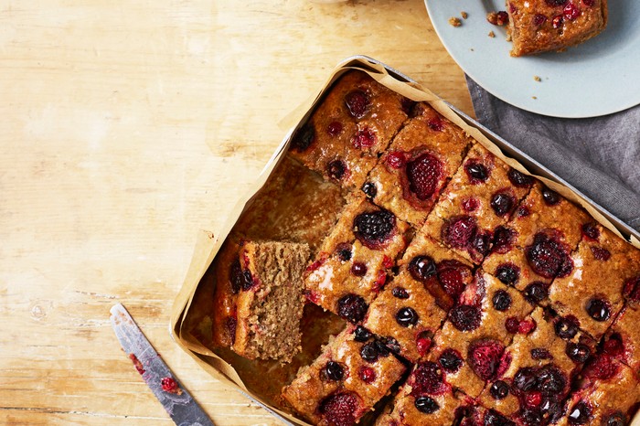 A tray filled with chunks of banana and berry cake