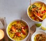 Two bowls filled with yellow dhal and topped with roast parsnips