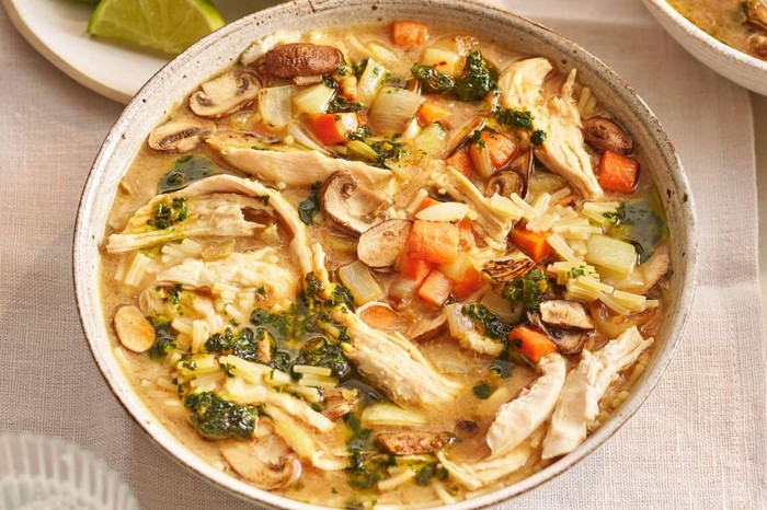 Two bowls of chicken soup on a set table