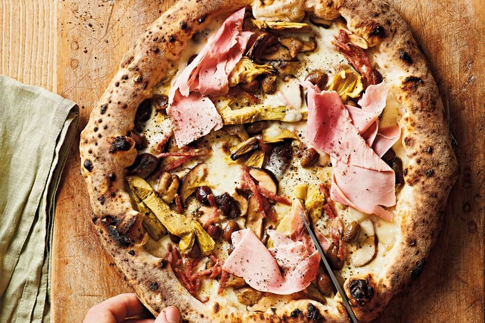 A whole ham and mushroom pizza with charred pizza crust