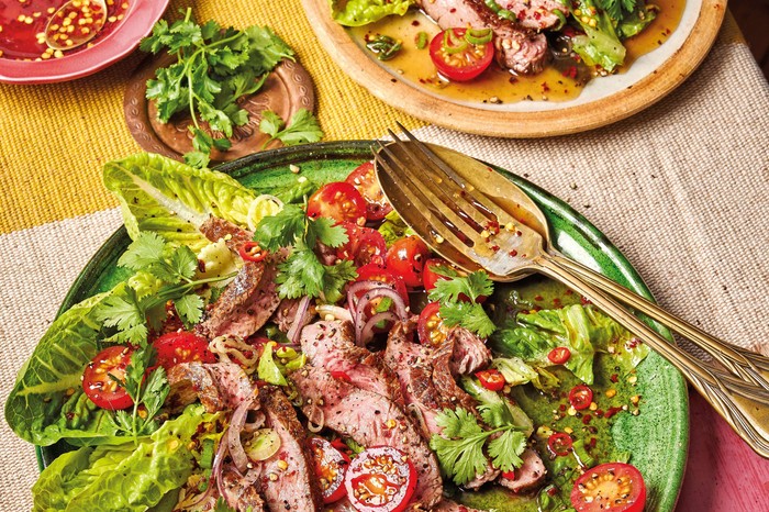 A dressed beef salad on top of lettuce leaves