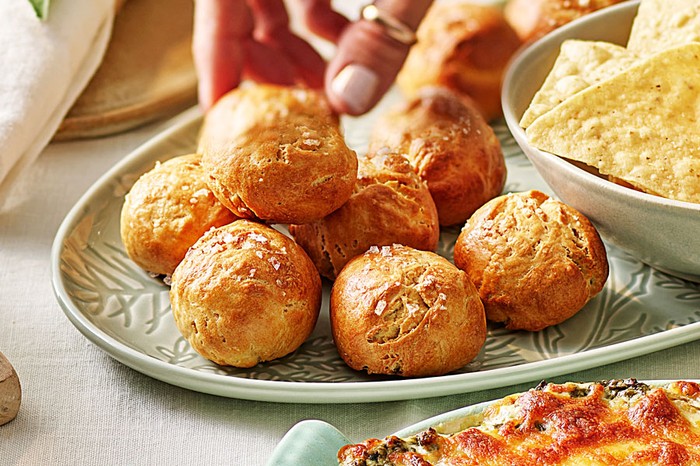 Hand reaching for a pretzel bite in a pile