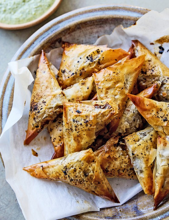 Samboosa in a pile on a platter with kitchen roll