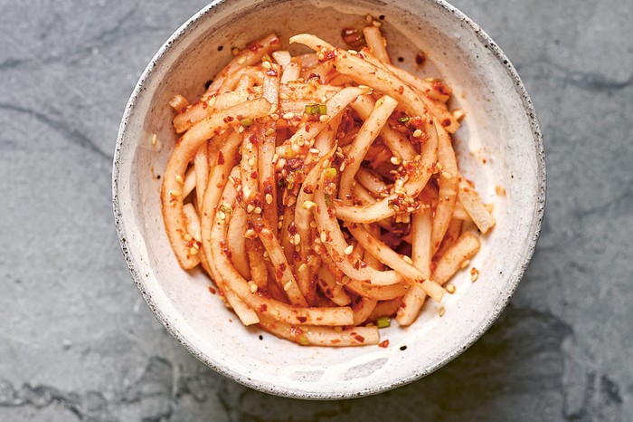 Bowl of julienned radishes topped with sesame seeds