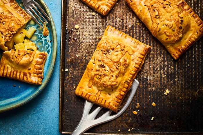 Fresh golden pasties on a cooling sheet