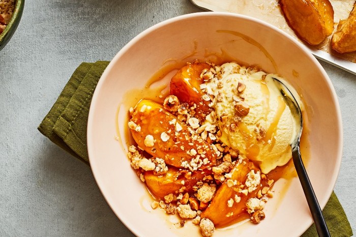 a pink bowl filled with caramel-coloured chunks of apple topped with crushed hazelnut