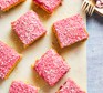 Squares of pink Tottenham cake on a board