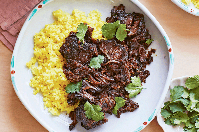 Eight-hour ox cheek rendang on a plate with fresh coriander