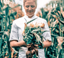 Chantelle Nicholson of Apricity holding vegetables in a field