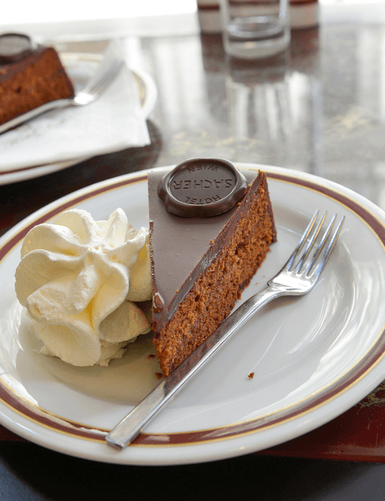 A slice of sachertorte, a famous Austrian cake with layers of apricot jam and a thick chocolate icing