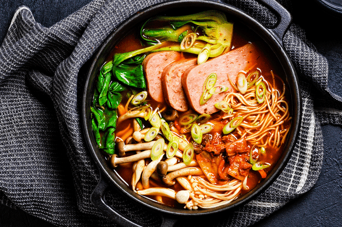 Korean-style ramen stew topped with slices of spam and spring onions