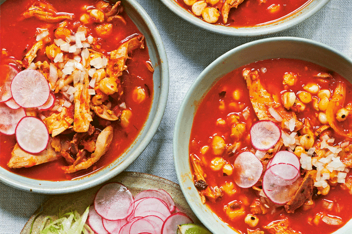 Chicken red hominy soup (Pozole rojo de pollo) in bowls on a table