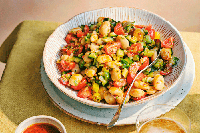 Bowl with butterbean salad with cherry tomatoes, cucumber and red onion